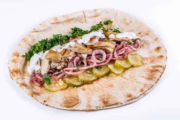 Opened shawarma with chicken, pickled cucumber, pickled onions, chopped parsley and garlic sauce on isolated white background