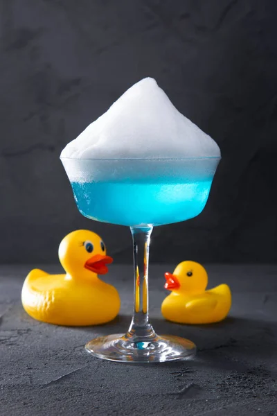 Cocktail Glass Ice Froth Stands Concrete Table Plastic Ducks — Zdjęcie stockowe