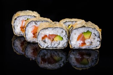 Roll in batter with salmon, perch, avocado, rice, nori, Philadelphia cheese on a black mirror background