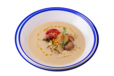 Mushroom sauce with pea sprouts, zucchini, mushrooms, tomatoes and corn in a plate on a white plate