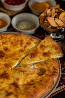 Tabağında peynir, üzüm, kurutulmuş elma, baharat ve bir bardak kırmızı şarap olan Khachapuri. Dikey yönelim 