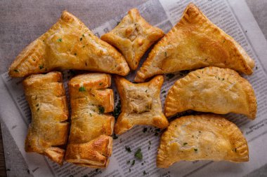 Parşömen üzerinde dereotu olan Samsa üçgenleri. Yatay yönelim 