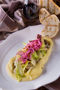 Kızarmış et parçaları patates püresi, salata, soğan ve sosla birlikte kızarmış ekmek ve bir bardak kırmızı şarap. Dikey yönelim