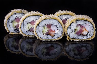 Warm roll in batter with tuna, scallop, eel, cucumber, tobiko caviar, nori and Philadelphia cheese on a black mirror background