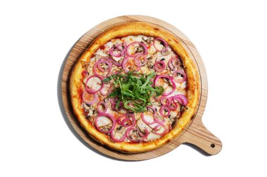 Pizza with cheese, mushrooms, onions, chicken, arugula and sauce on a wooden board on a white plate