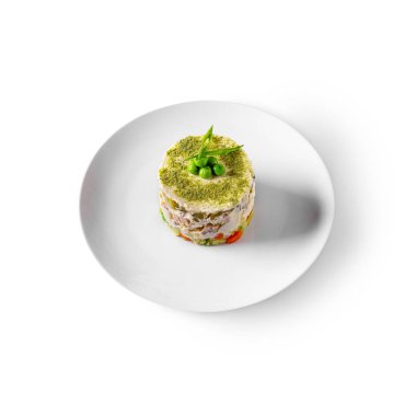 Cake with peas mayonnaise, tomatoes, lettuce, corn, cucumbers and peppers in a bowl on a white background