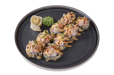 Warm roll in batter with sesame seeds, fish, sauce, cucumber, rice, nori, onion, wasabi and ginger in a dish on a white plate