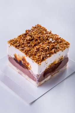 Milk dessert ice cream with different layers, and chopped nuts on a light background. Vertical orientation