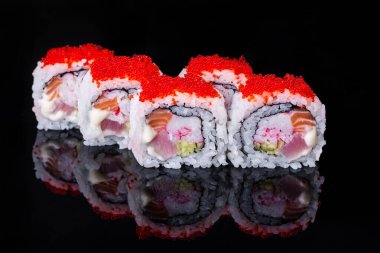 Roll with salmon, tuna, cucumber, rice, tobiko caviar, Philadelphia cheese on a black mirror background