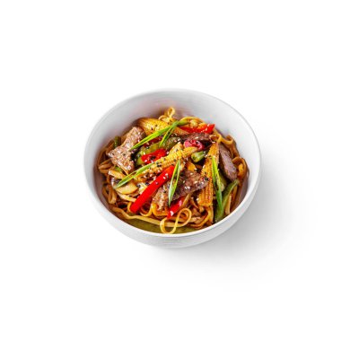Spaghetti with corn, pork steaks, mushrooms, onions, sesame seeds, pepper in a plate on a white background