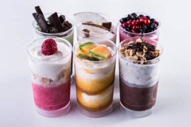 Vanilla ice cream in two glasses with melon jam and melon pieces on a light background. Vertical orientation