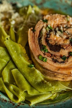 Yuvarlak tabakta spagetti ve peynir soslu kızarmış köfte. Dikey yönelim