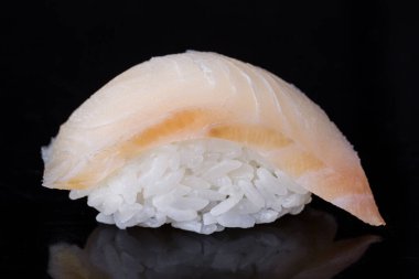 Roll with perch and rice on a dark mirror background