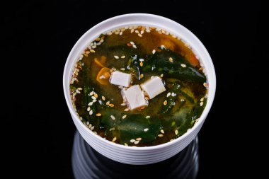 Peynirli Miso çorbası, kuşkonmaz fasulyesi ve arka planda bir tabakta et.