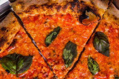 Pizza with cheese and basil in a plate on the table