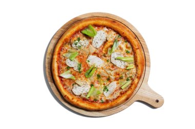 Pizza with cheese, chicken, salad, pineapple and sauce on a wooden board on a white plate