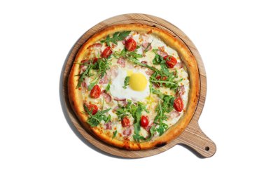 Pizza with egg, arugula, cheese, tomatoes, bacon and sauce on a wooden board on a white background