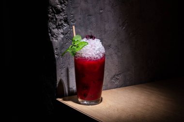 Buzlu, naneli, yaban mersinli ve bardakta pipetli bir kokteyl.