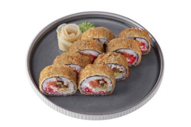 Warm roll with sesame seeds in batter with sauce, cheese, salmon, eel, avocado, tobiko caviar, rice, nori, wasabi and ginger in a dish on a white plate