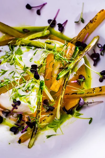 Peynirli salata, taze filizler, sos ve biber masada.