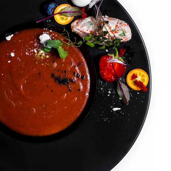 Gazpacho çorbası, kumkat, tobiko havyar, yabanmersini, çilek, krema şekeri ve tatlı hamur işi, beyaz arka planda krema.