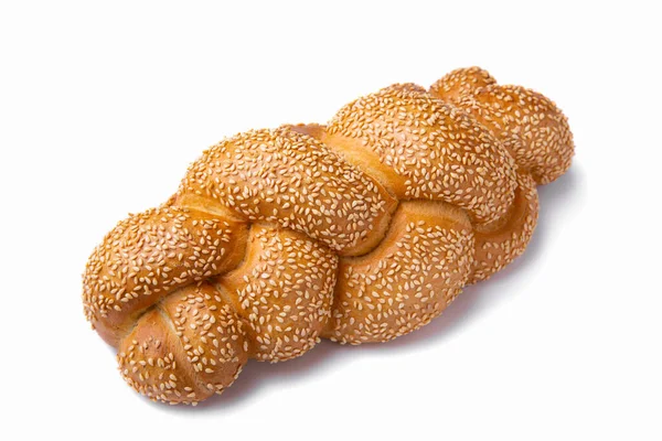 Braided bread made from wheat flour with sesame seeds on top on a white background.