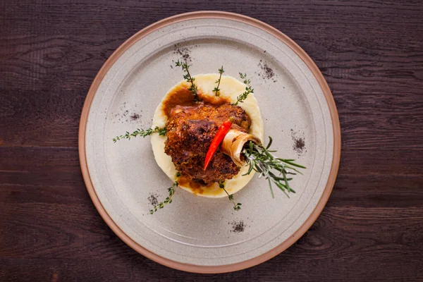 Kemiğe kuzu rostosu, kekik, biberiye, biber ve ahşap bir zeminde patates püresi. Yatay yönelim