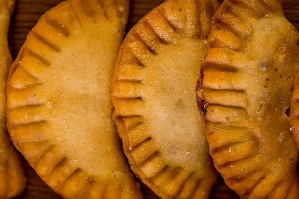 Altın börekler, yakın plan, tahta bir tahtanın üzerinde. Dikey yönelim 