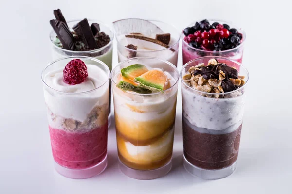 Vanilla ice cream in two glasses with melon jam and melon pieces on a light background. Vertical orientation