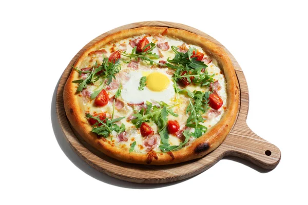 Pizza with egg, arugula, cheese, tomatoes, bacon and sauce on a wooden board on a white background
