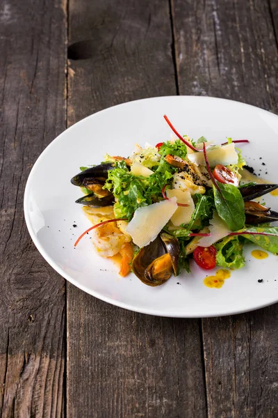 Midye, karides, peynir, hindiba, roka, domates ve soslu salata.