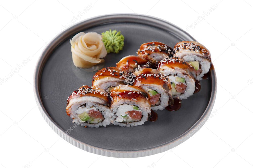 Roll with philadelphia cheese, salmon, sesame seeds, sauce, eel, avocado, rice, nori, wasabi and ginger in a dish on a white plate