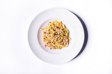 Pasta with cheese, parsley and meat in a plate on a white background