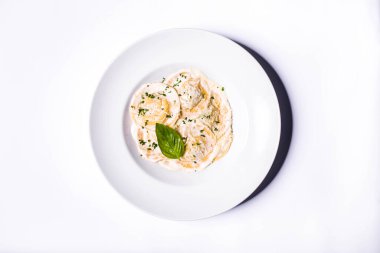 Beyaz soslu, peynirli, maydanozlu ve fesleğenli Ravioli.