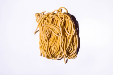 Beyaz arka planda pişmemiş spagetti. Yatay yönelim 