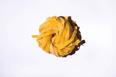 Beyaz arka planda çiğ, geniş bir spagetti. Yatay yönelim 