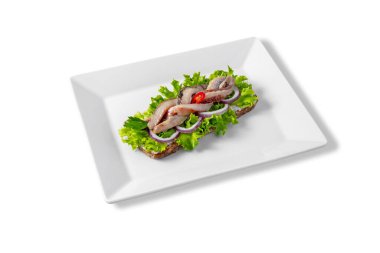 Sandwich with fish, salad, sauce and pepper in a white plate on a white background