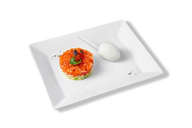 Salad with salmon, cucumbers, avocado, basil, red caviar and Philadelphia cheese with egg in a plate on a white background