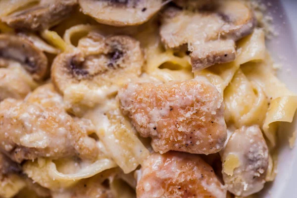 Pasta with meat, champignon, cheese, on a plate on the table