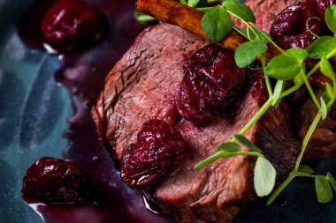 Vişne soslu ızgara domuz eti ve yuvarlak tabakta duran fasulye salatası. Yatay yönelim 