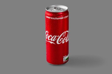 A jar of Coca-Cola with drops from the cold stands on a gray background.