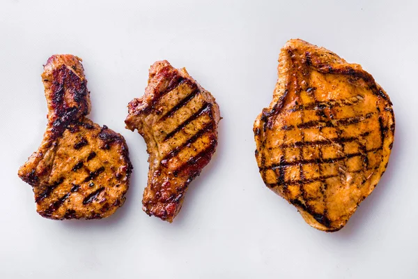 Pieces of grilled meat on a white plate. Horizontal orientation
