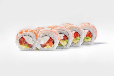 Sushi tiger dragon with shrimp. Filled with salmon, avocado, red tobiko caviar, wrapped in nori seaweed, rice and tiger shrimp. Roll stands on a white background.