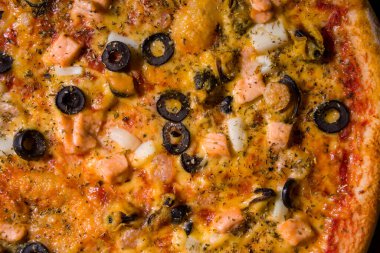 Pizza with olives, salmon, squid, mussels, cheese and seasoning