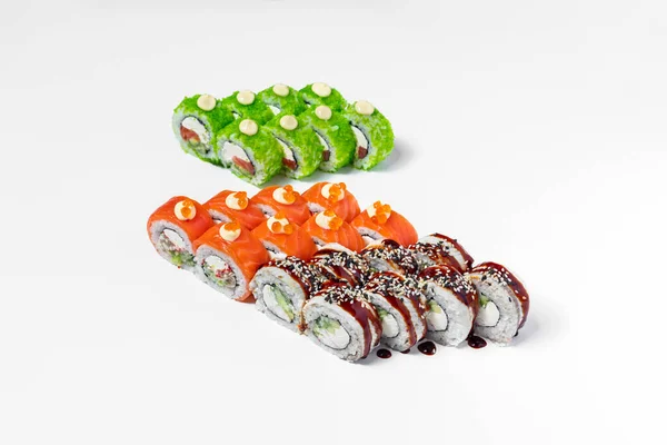 Sushi set dragon. Three sushi rolls stand on a white background. Sushi black dragon with eel. red dragon sushi with salmon and green dragon sushi with tobiko and shrimp.