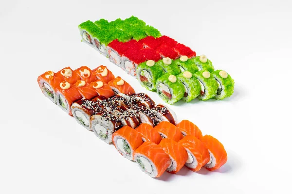 Sushi set maximum. Six sushi rolls stand on a white background, Sushi golden dragon with eel and salmon, philadelphia with salmon, philadelphia with eel, green dragon in tobiko, green tobiko with salmon, red tobiko with shrimp.