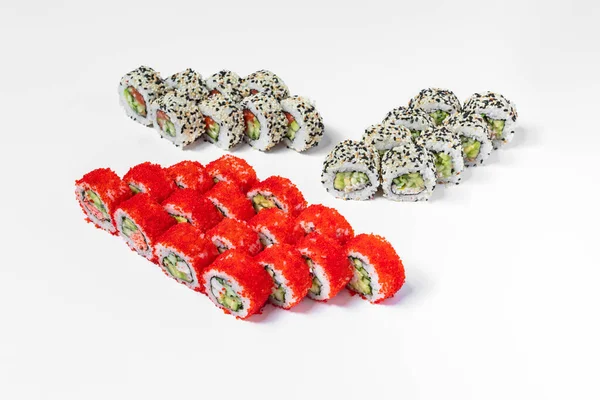 California sushi set. Four sushi rolls stand on a white background. California with red tobiko caviar and shrimp, California with red tobiko caviar and crab meat, California with sesame and trout, and California with sesame and eel.