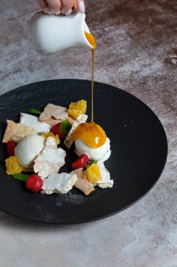 Arkaplanda bal, çilek, portakal, hamur işi ve nane şekeri dolu dondurma topları var.