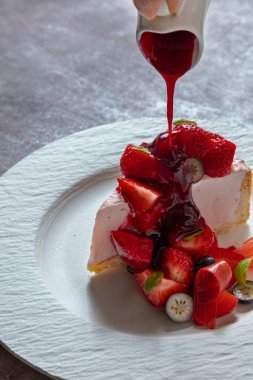 Çilekli reçelli cheesecake, yaban mersinli ve marşmelovlu bir tabakta