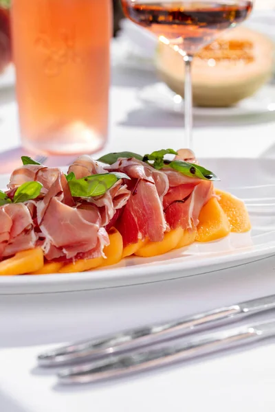 Salad Melon Prosciutto Basil Leaves Balsamic Dressing Nearby Bottle Rose — Stockfoto